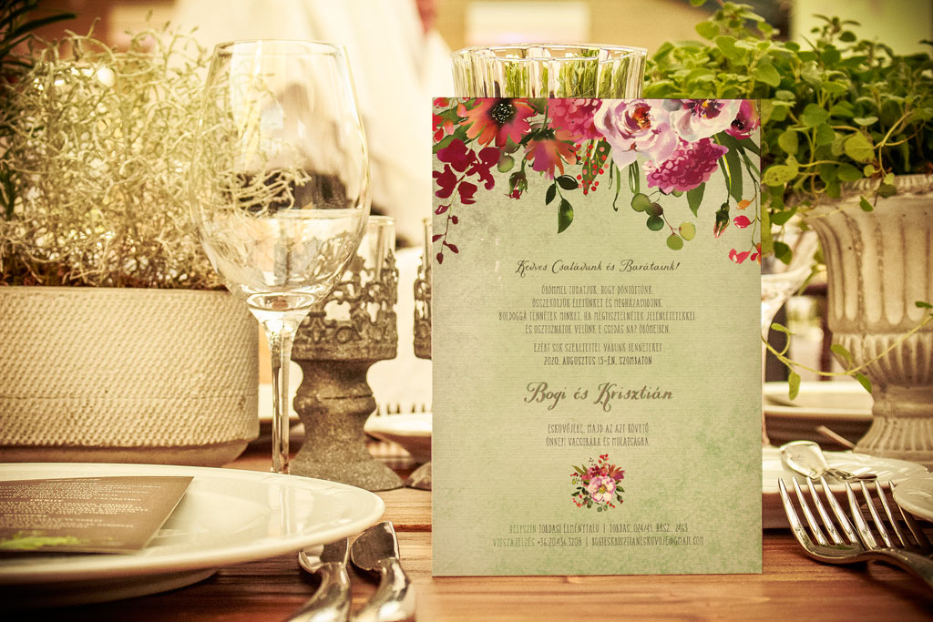 Babarózsás esküvői meghívó, halvány rózsaszín és élénk bíbor virágokkal, zöld leveles díszítéssel, halvány zöld alnyomattal, finoman rusztikus tipográfiával 