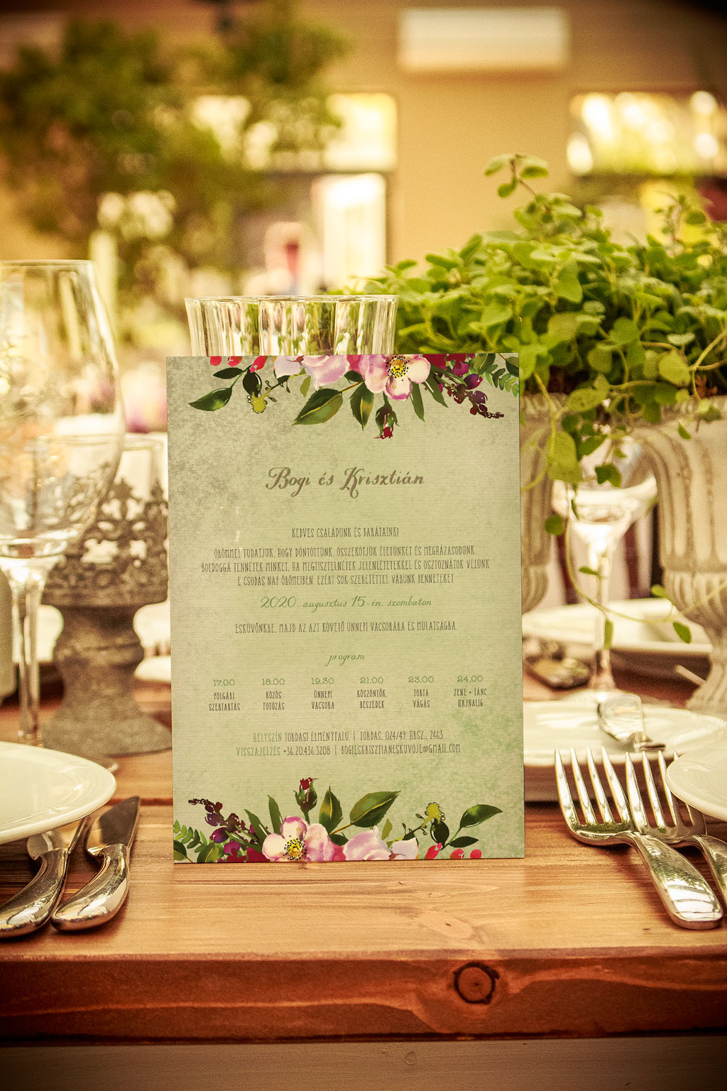 Babarózsás esküvői meghívó, halvány rózsaszín és élénk bíbor virágokkal, zöld leveles díszítéssel, halvány zöld alnyomattal, finoman rusztikus tipográfiával 