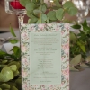 Pink virágos esküvői meghívó élénk és vibráló árnyalatokkal, sok zöld levéllel és halvány zöld alnyomat grafikával, letisztult és modern tipográfiával