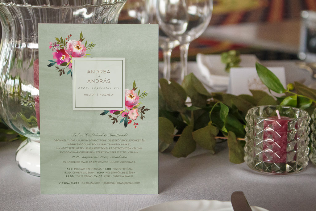 Pink virágos esküvői meghívó élénk és vibráló árnyalatokkal, sok zöld levéllel és halvány zöld alnyomat grafikával, letisztult és modern tipográfiával 