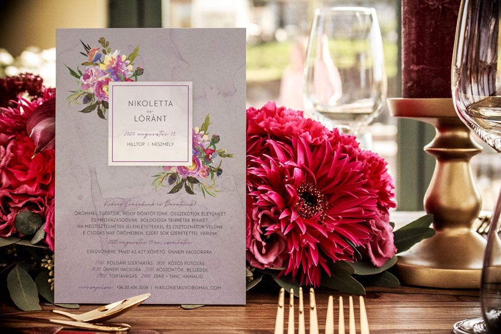 Nyári bazsarózsás esküvői meghívó élénk rózsaszín, halvány levendula és sárga virágok kombinációjával, sok zöld levéllel, modern és látványos tipográfiával.