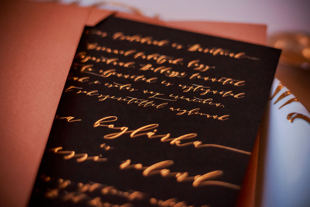 Teljes felületében fólianyomással készült szuperkülönleges kalligrafikus arany meghívó, prémium minőségű fekete papírokra nyomtatva