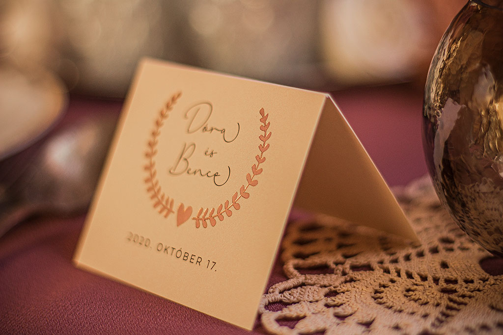 Aranyozott esküvői kiegészítők a Bay Leaf meghívó babérkoszorús grafikájával poháralátét, menükártya, ültetőkártya, ültetésitábla