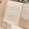 Gyöngyházfényű tasakos meghívó ekrü-pezsgő és ekrü-púder színpárban, virágos monogram kompozícióval, papírbrossal és két infókártyával