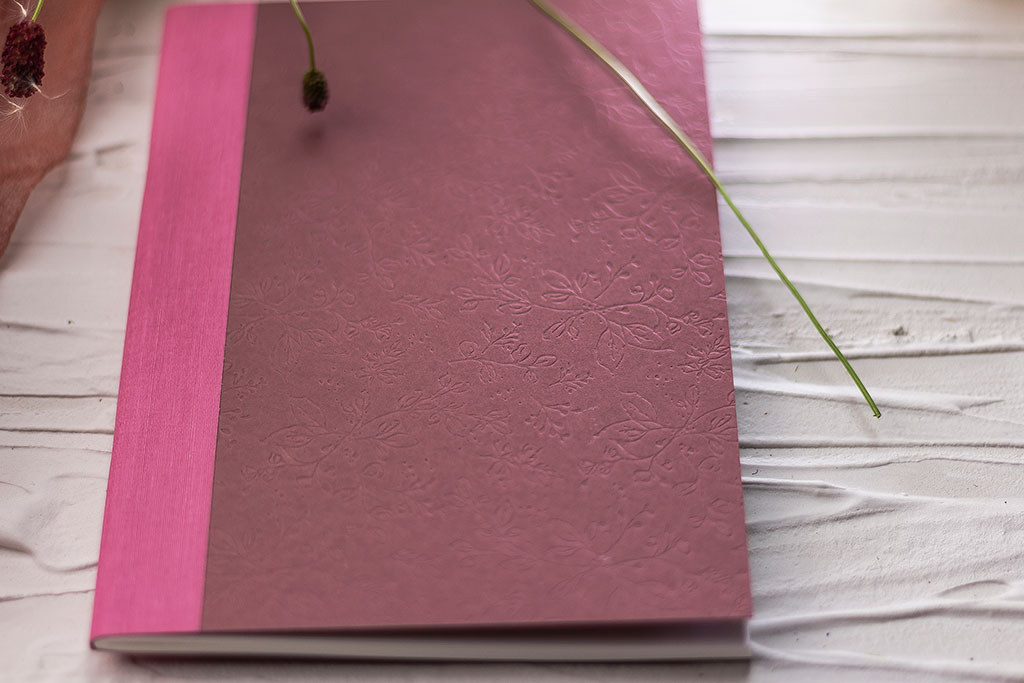 Mezeivirágos füzet mályva-pink borítóval vaknyomással és gerincvászonnal díszítve, A/5-ös méretben 64 oldalas terjedelemben, 9 különböző színkombinációban