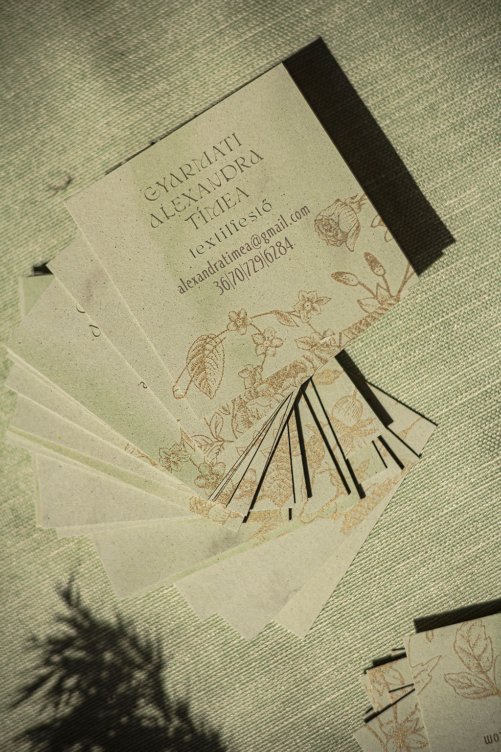 Négyzetes névjegy digitális arany nyomtatással kétféle öko-papírból két rétegben kasírozva 35 különböző virág grafikával, pasztell zöld és kakaó kartonokból