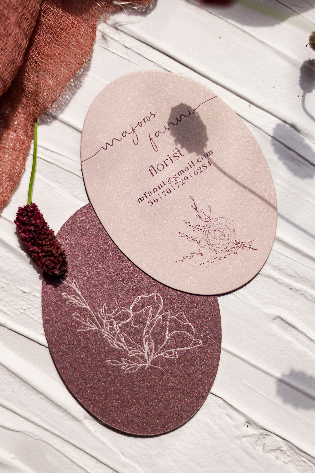 Ovális névjegy púder papírból aranyos fényű pasztell előoldal és erősen csillogó gyöngyházfényű hátoldali kartonból kasírozva tízféle virág grafikával