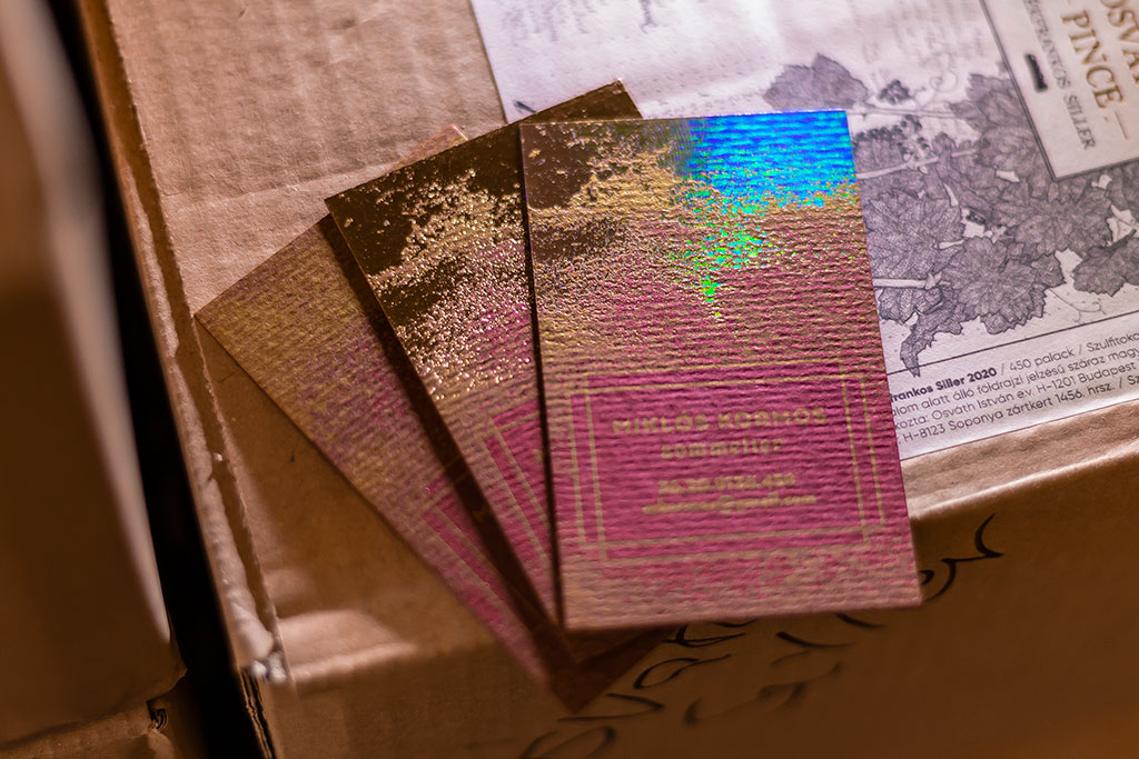 Digitális arannyal nyomtatott bordó névjegy két rétegben kasírozott struktúrált papírból, modulárisan variálható extrákkal, prégeléssel és/vagy stancolással