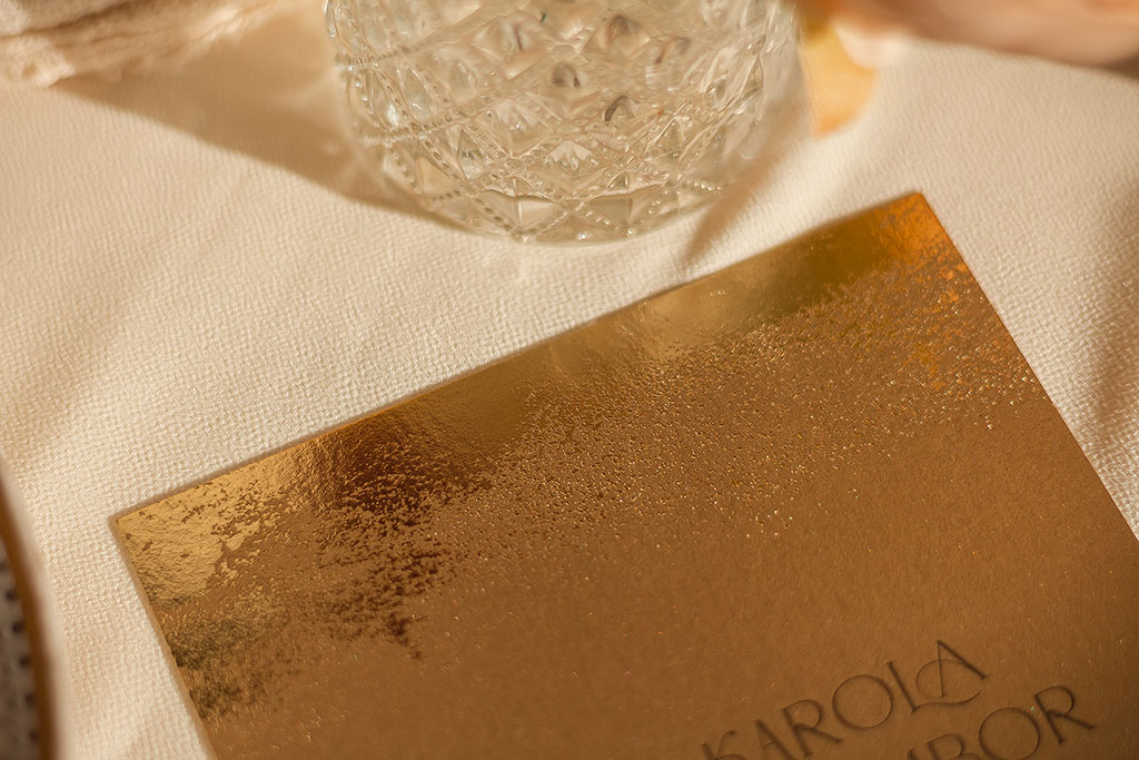 Aranyozott arany meghívó öt különböző gyöngyházfényű papírra, textúrázott prégeléssel ugyanolyan menükártya, ültetési lapok és asztalszámozó is rendelhető