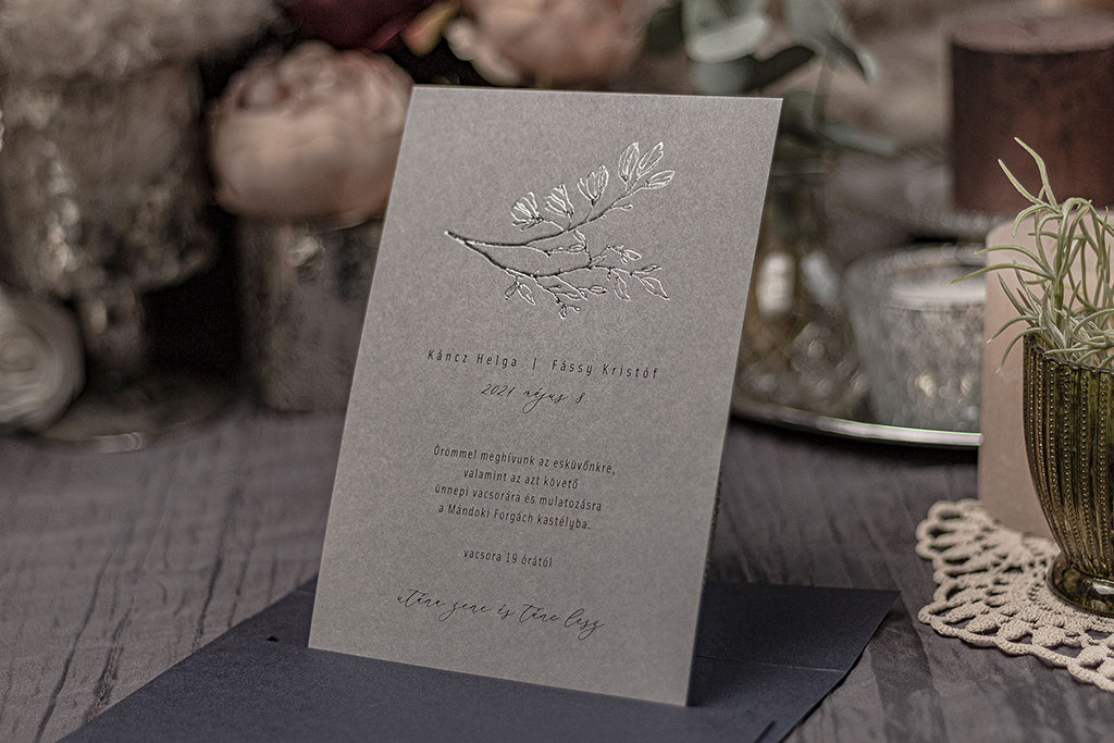 Ezüst virágos meghívó választható árnyalatú halvány szürke papíron, fekete szöveg nyomtatással és fényesen csillogó ezüst fóliaprégeléssel