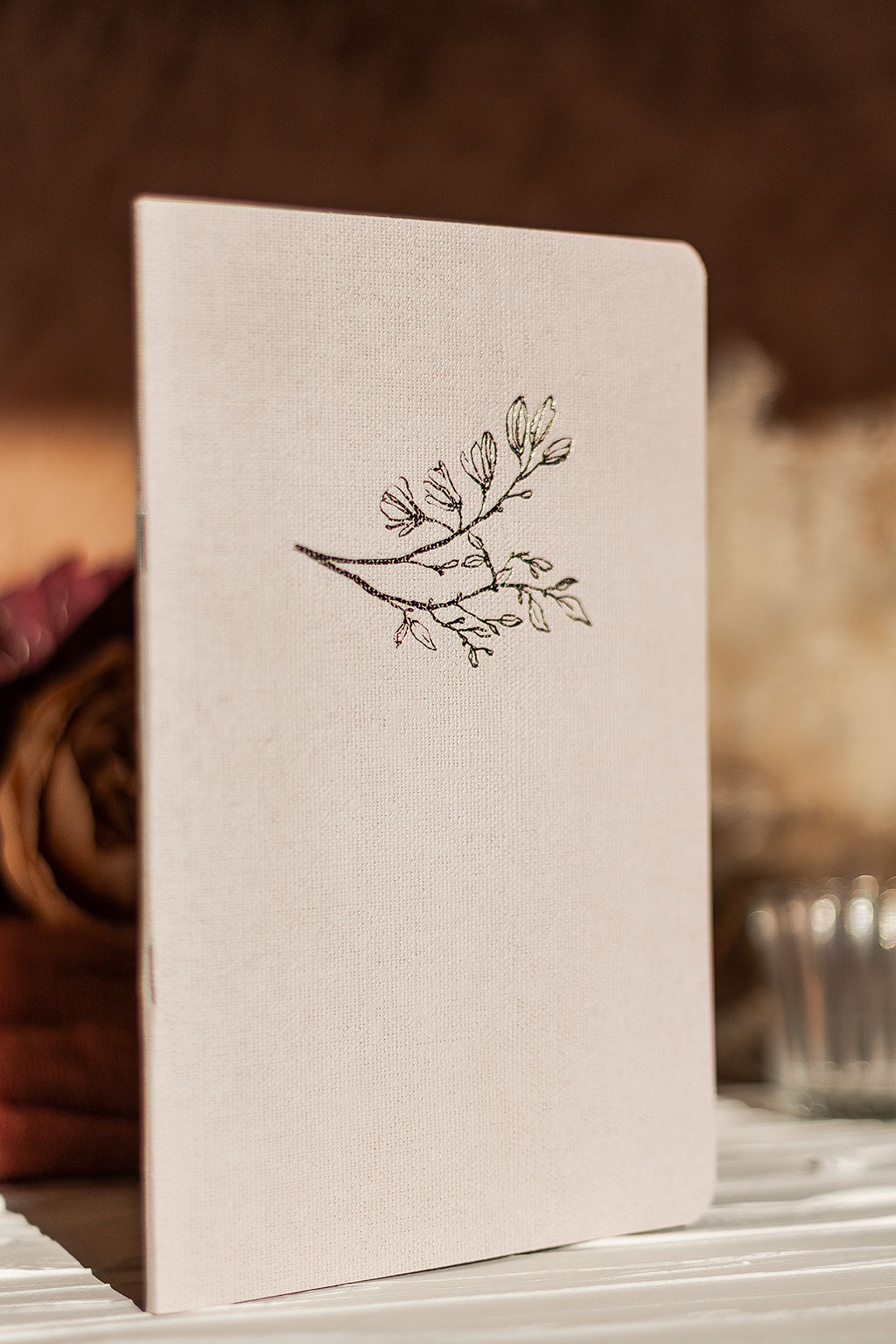 Vászonfelületű kartonból készített füzet arany virággal prégelve: A/5, 64 oldalas, pontozott vonalas, fehér belívvel, sarokkerekített, egyedi paraméterekkel is rendelhető