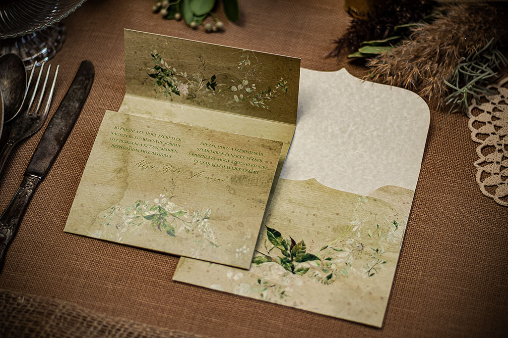 Rusztikus hangulatú greenery grafikával készített meghívó speciális felületű, öregített hatású, márványos prémium papírból, nyomtatott borítékkal