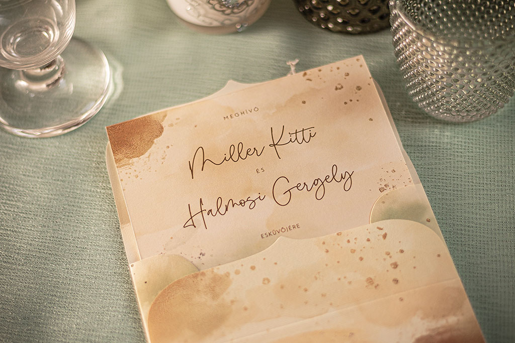 Greenery-arany grafikával díszített mesküvői meghívó és hozzá való nyomtatott boríték, kétféle grafikával, krém színű papírokon