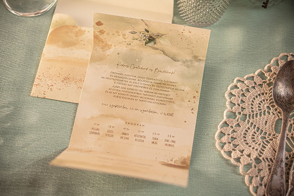Greenery-arany grafikával díszített mesküvői meghívó és hozzá való nyomtatott boríték, kétféle grafikával, krém színű papírokon