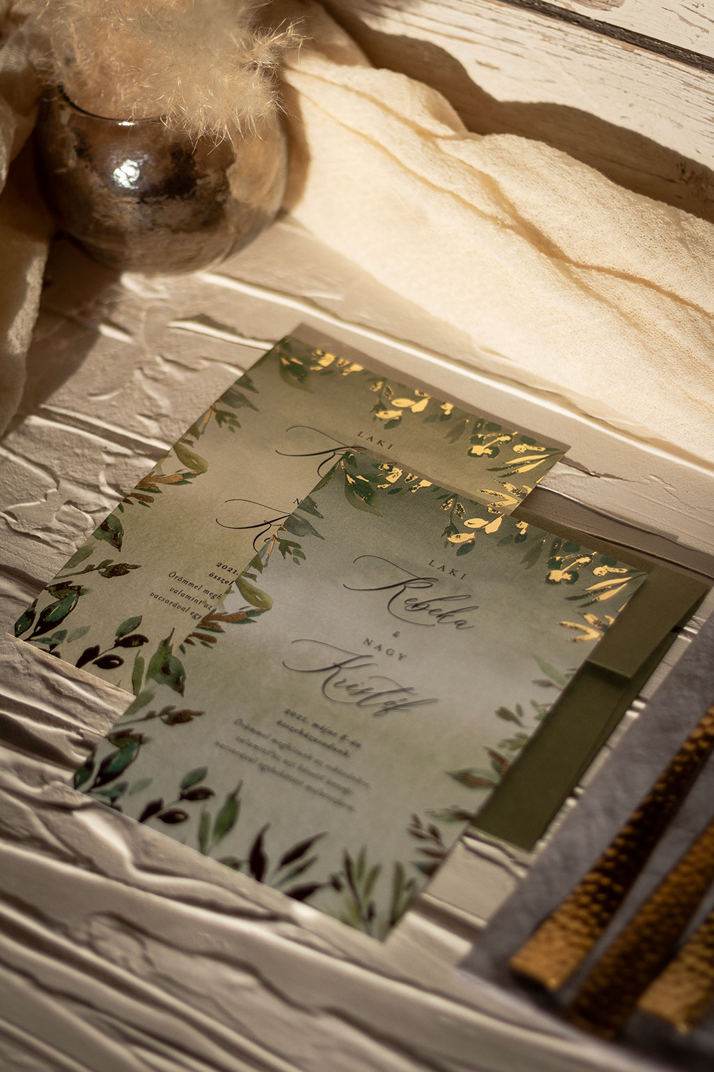 arany leveles greenery meghívó külső keretes díszítő grafikával és csillogó arany fólianyomással díszítve, fehér és krém színű aranyfényű papíron